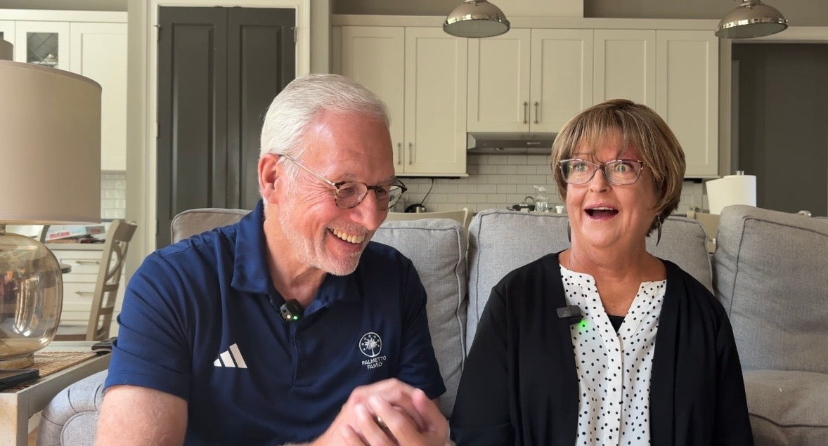 Steve and Terry Pettit sharing a lighthearted moment on their sofa.
